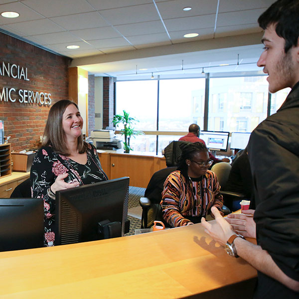 A Brandeis staff member talks to a student in the Advising office