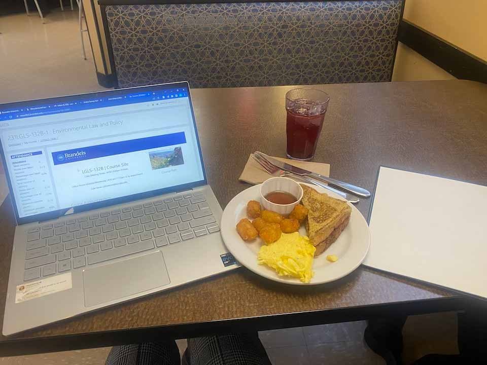 Computer and breakfast plate on a table