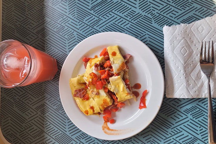 A tray with an omelet and juice