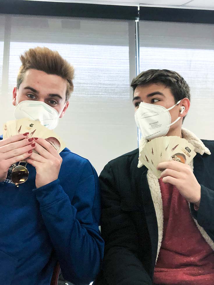 James and Peyton wearing masks, holding cards