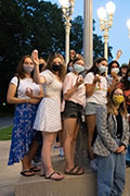 Students wearing masks standing with LTW sculpture