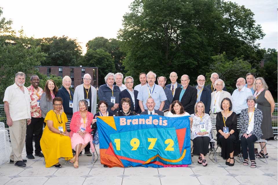 The Class of 1972 poses outside with their class banner. 