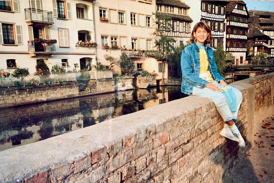 Mara Posner Metzger sitting on top of a wall in Strasbourg, France.
