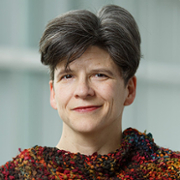 Woman with short hair, multicolored sweater.
