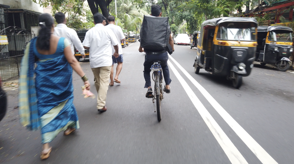 Biker on the center lane of a busy street