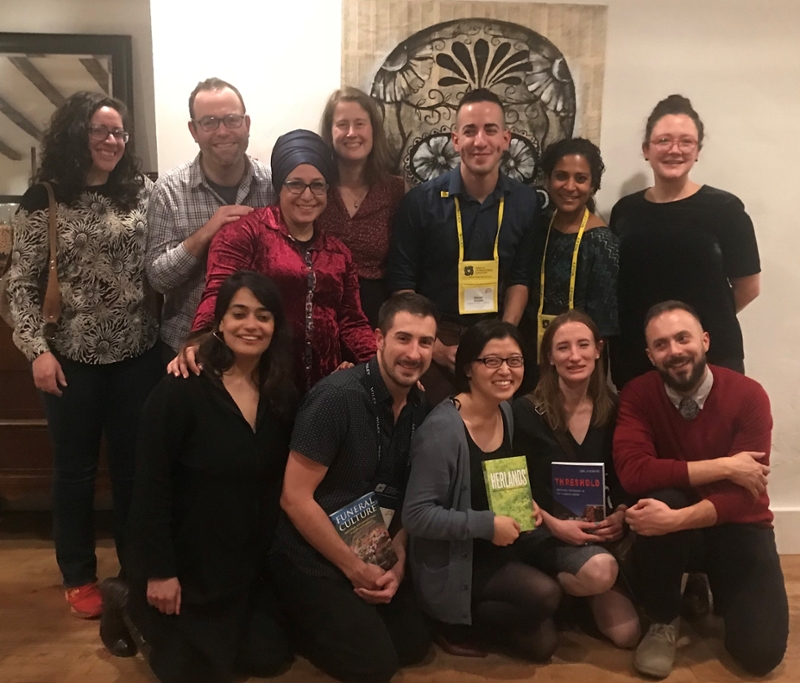 A group of people holding books and smiling at the camera