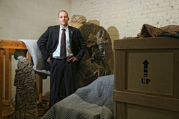 Brenton Easter stands in front of large artifacts