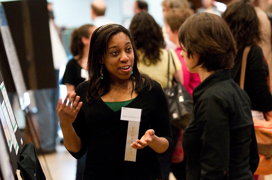 A student talks to a professor during a poster presentation