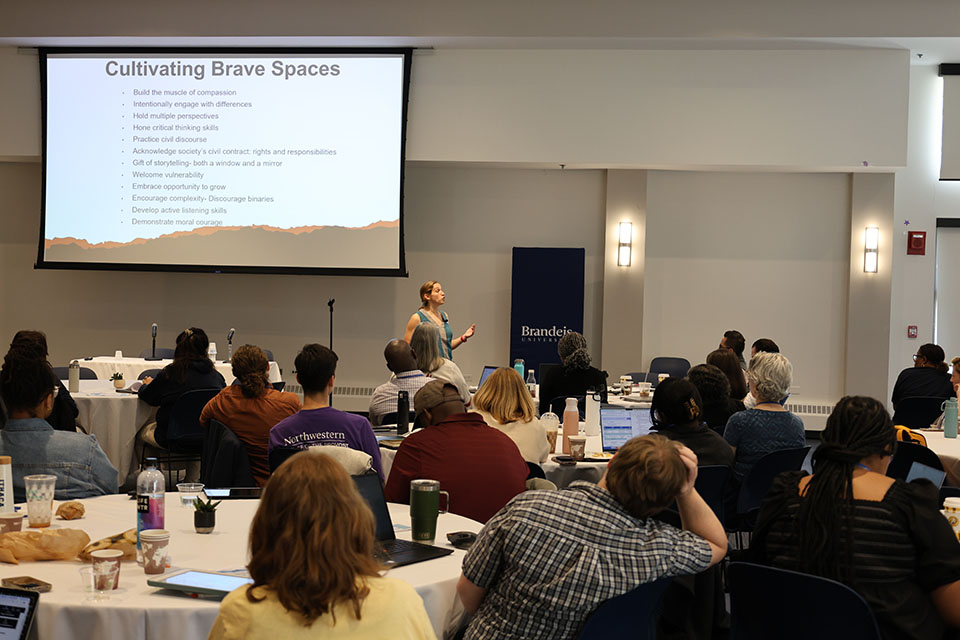 Photo of Rachel Fish teaching with slide in background titled "Cultivating Brave Spaces"