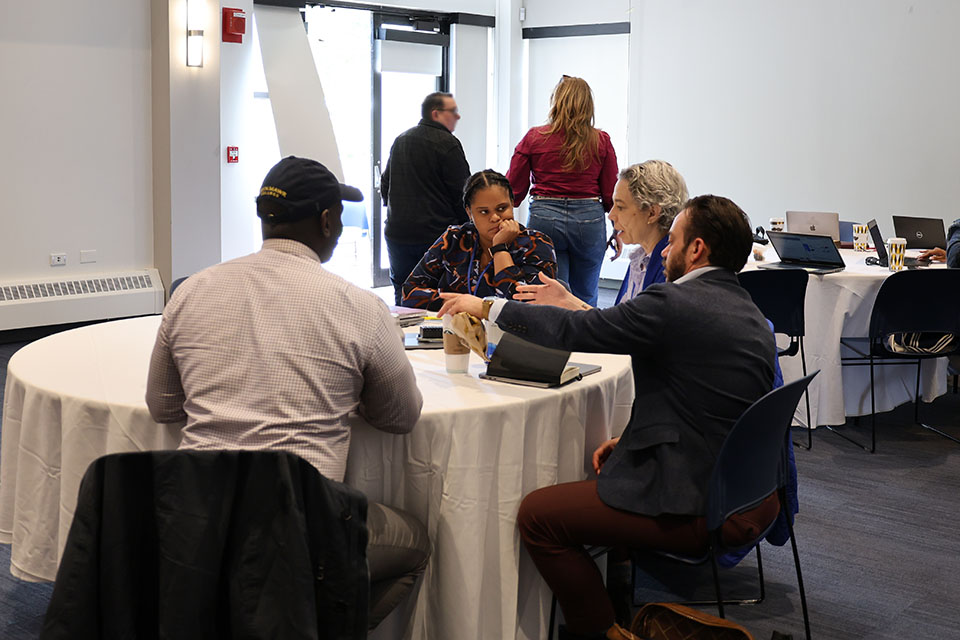 Four-person team discussing around table.