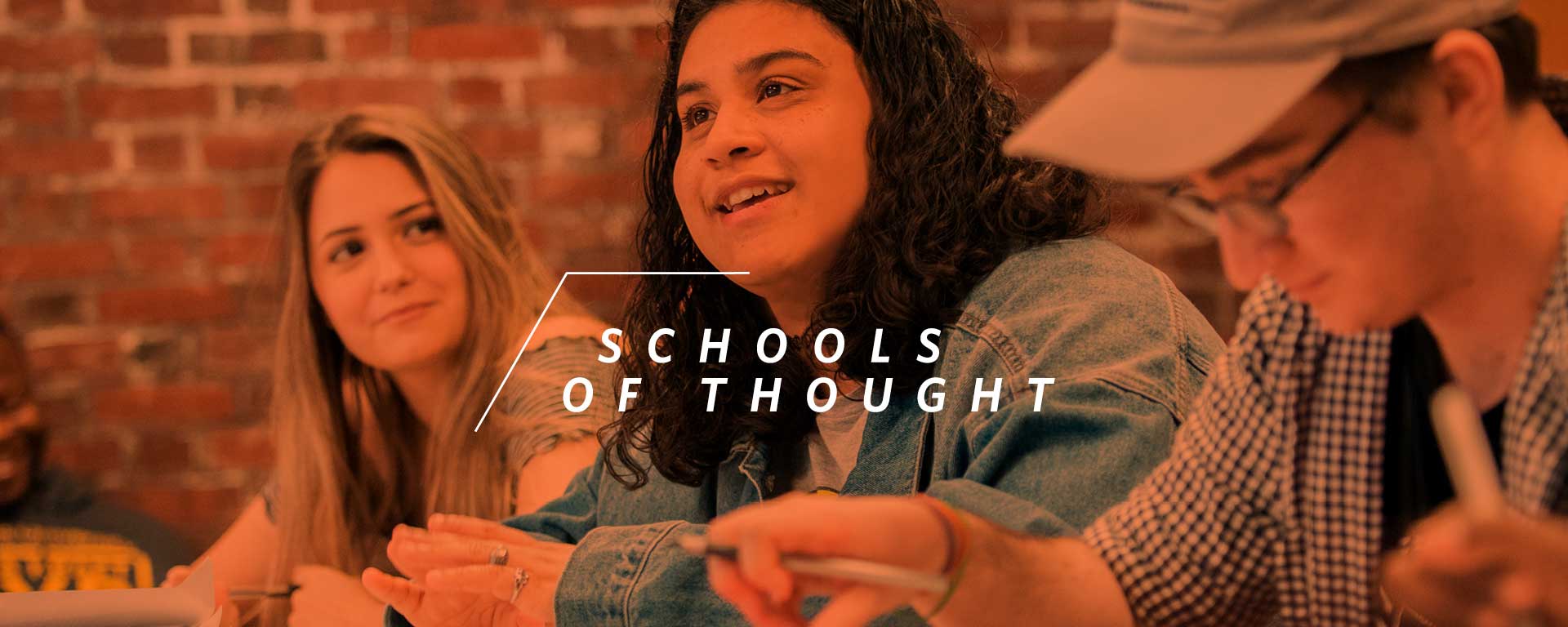 three students seated at their desk in classroom, overlaid by words schools of thought.