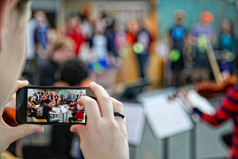 The view of people gathering in the SCC through a cell phone screen.