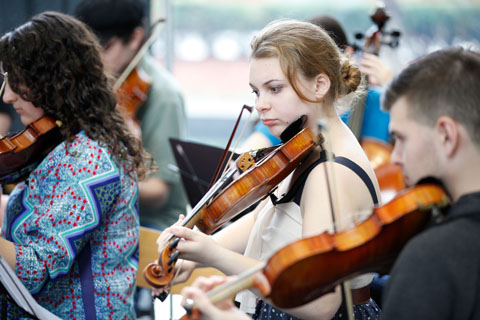 Several violinists performing.