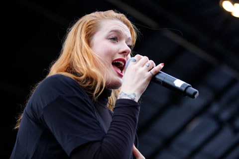 Female performer singing into the microphone at Chapels Field.