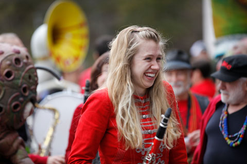 A flutist in a red jacket laughs at the festival.