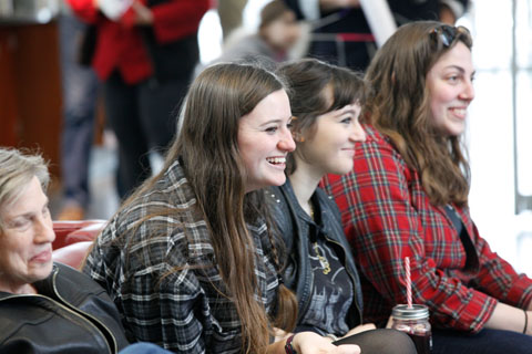 Four seated women smiling and enjoying the festival events.