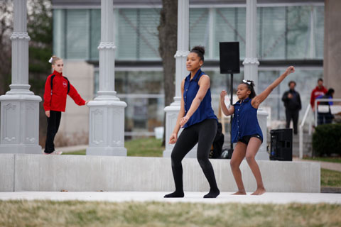 Young performers dancing in front of the Rose Art Museum.