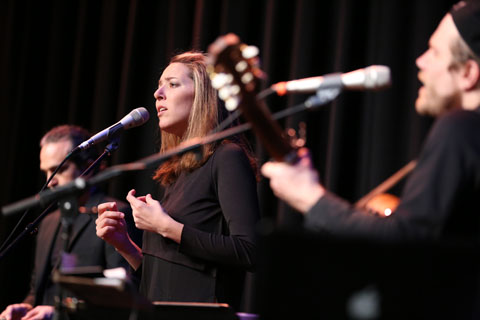 Performers from the Guy Mendilow Ensemble singing and playing instruments.