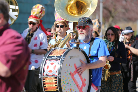 Members of Somerville’s School of Honk playing their instruments, including a drummer and various horn instrumentalists.