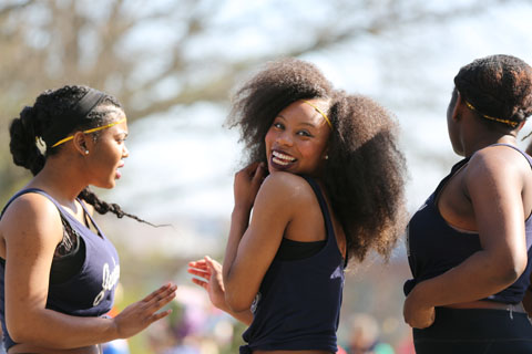 Candid photo of three members of performance group “Toxic,” one of whom is smiling brightly at the camera.