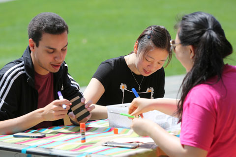 Three students at a table doing crafts.