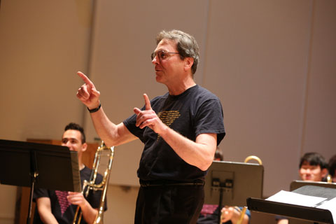 A conductor preparing to lead the orchestra in a performance.