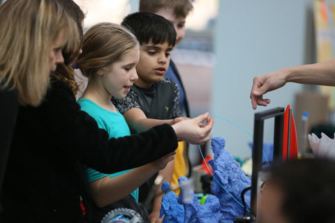 Children engaged in 3D printing.