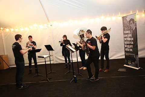 Group of people playing various brass instruments.
