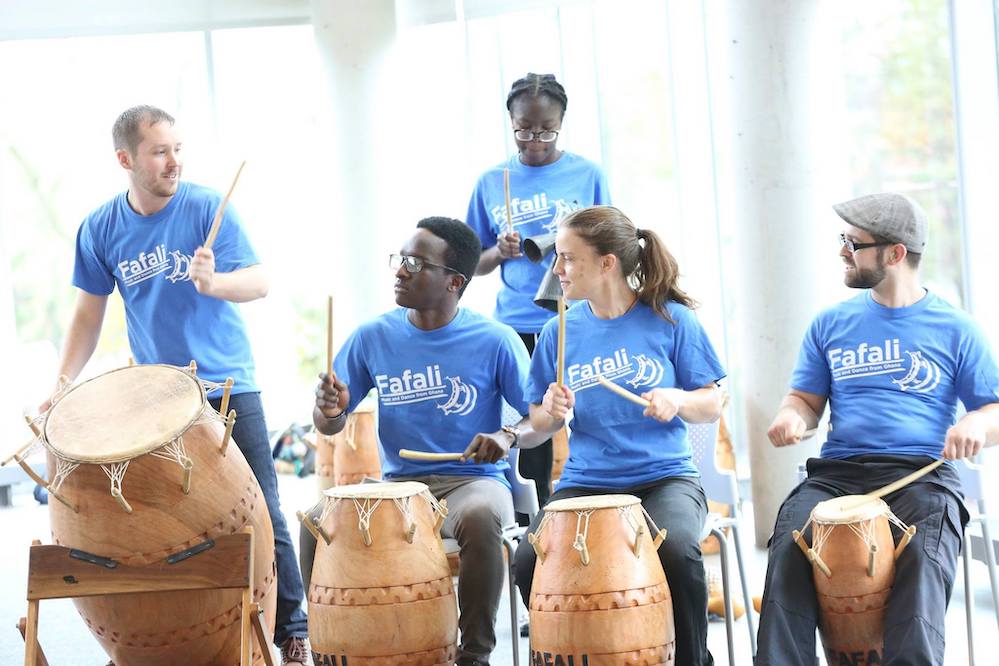 group of students sitting down playing the drums 