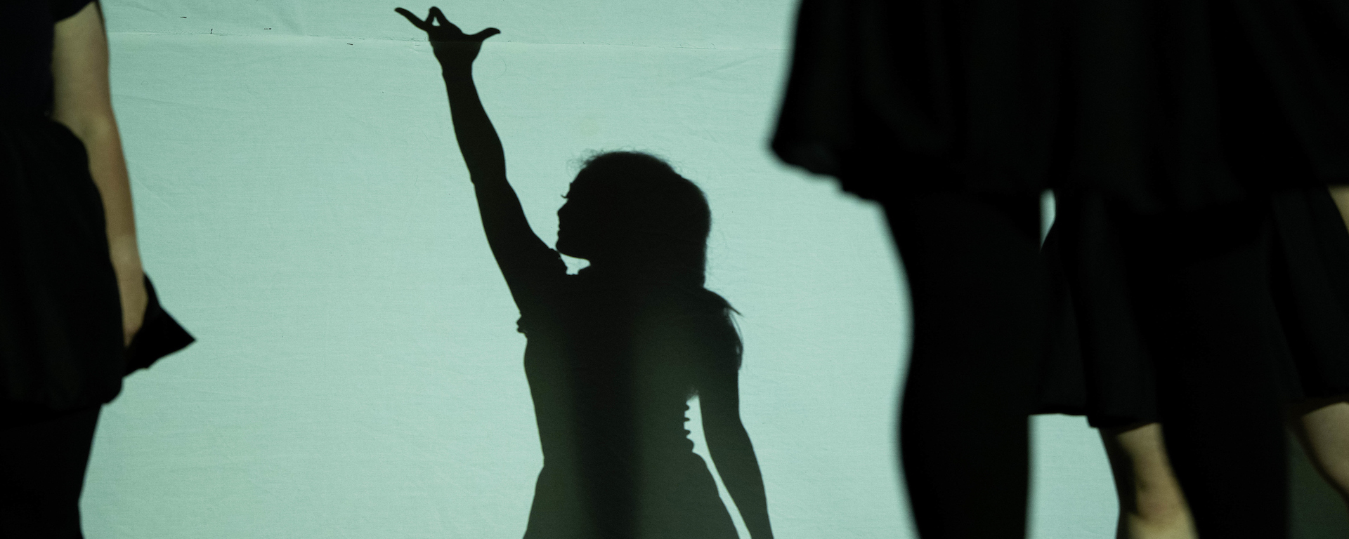 Dancer in silhouette with arm stretched high