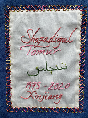 Sewn patch with the name Shazadigul Tomur