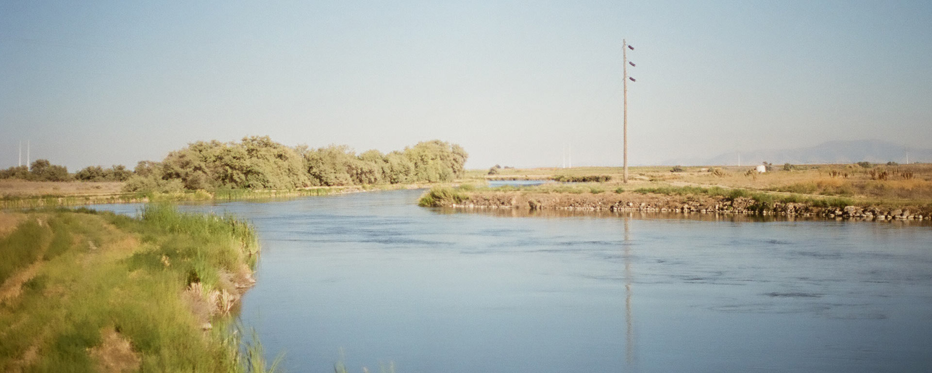 Landscape with water and fields, a building in the background