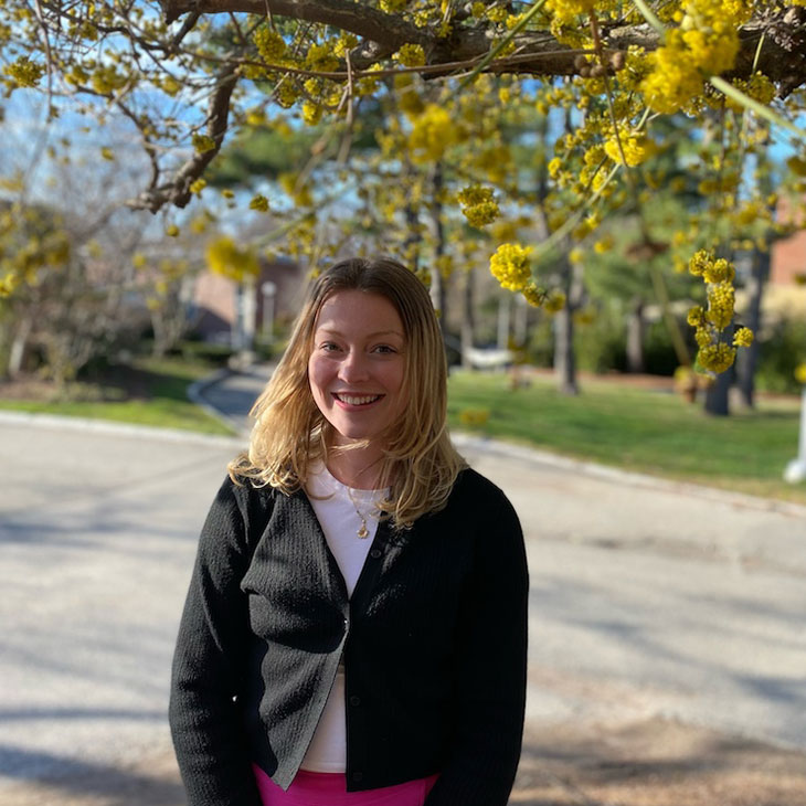 Adah Anderson smiles under a flowering tree.