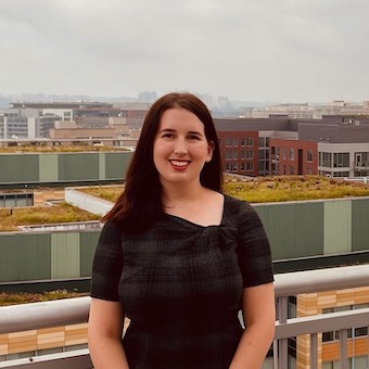 Kim, pictured standing on a rooftop in a black shirt, smiles.