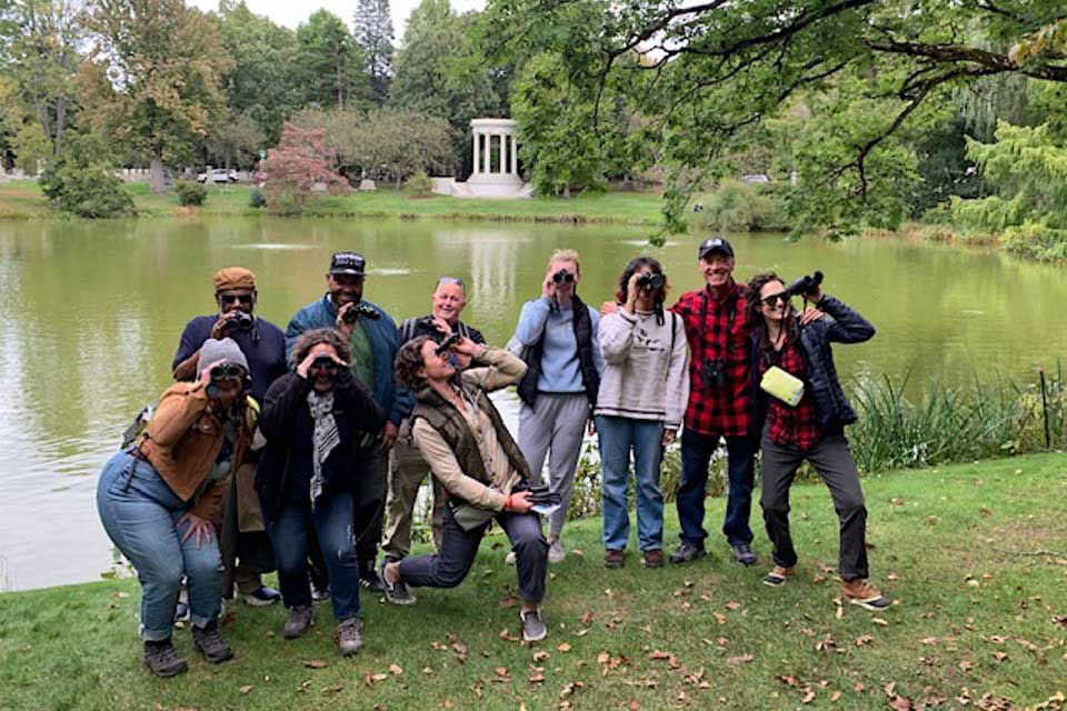 Members of the Partakers Empowerment Program community pose with binoculars.