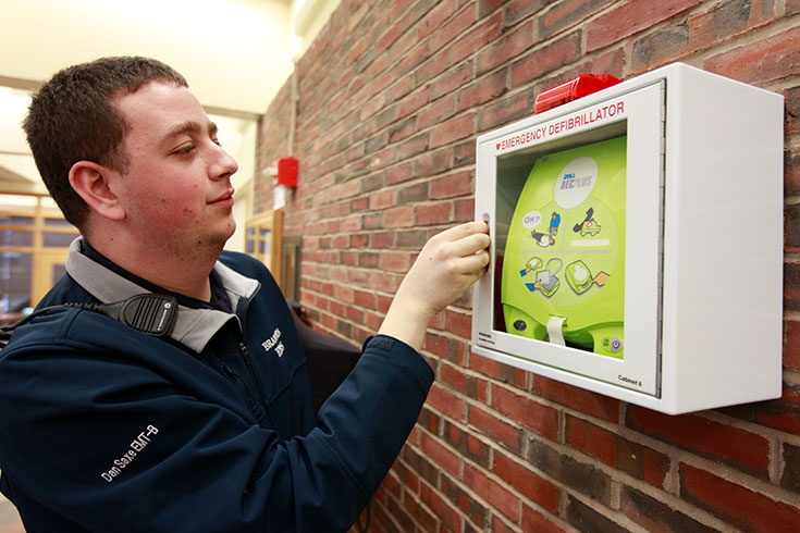 A BEMCo member opens a defibrillator installed on a wall