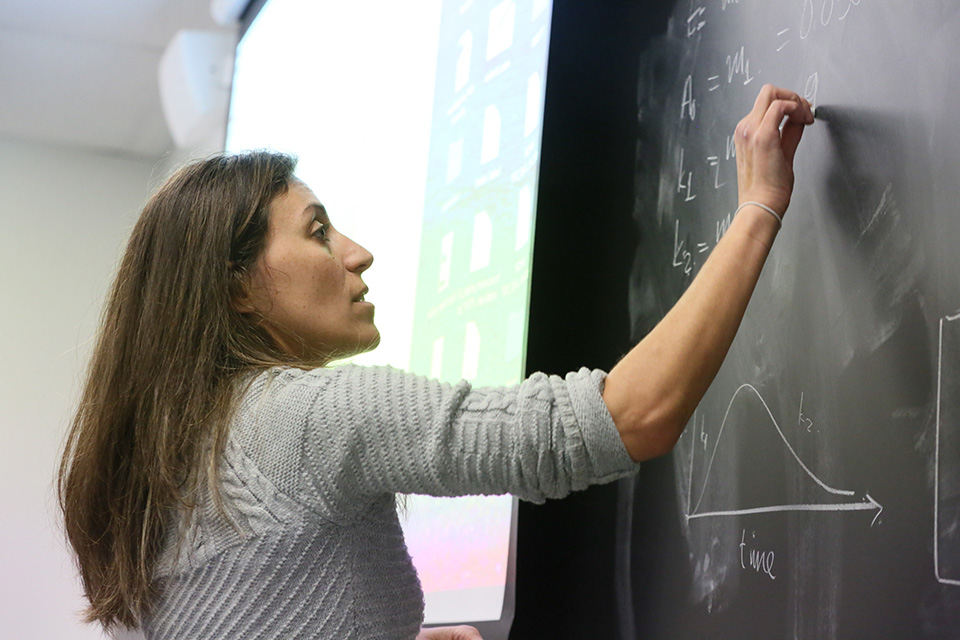 Biochemistry professor writing on board in classroom