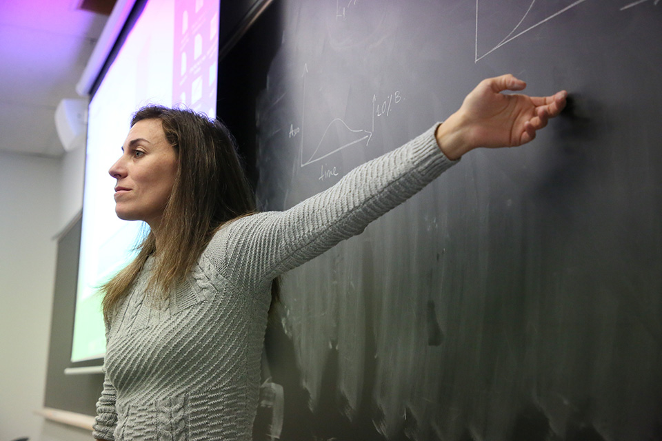 Biochemistry professor in front of chalkboard in class