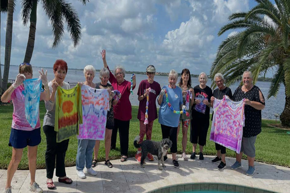 Members holding tie die shirts