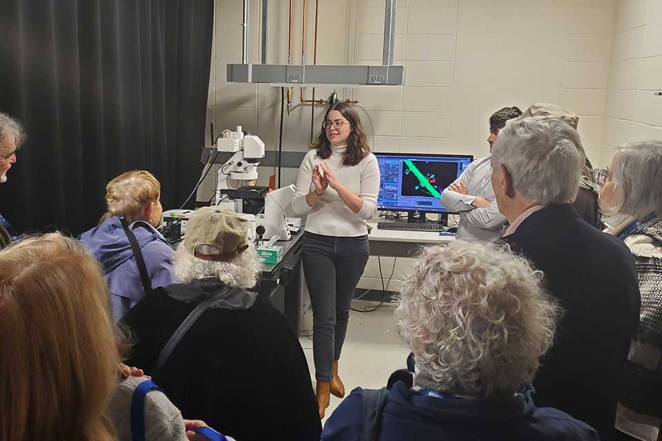 Student gives a lab presentation to BNC members on tour