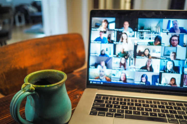 coffee mug next to zoom screen on laptop