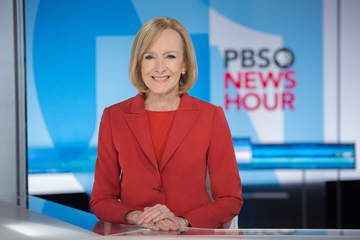 Judy Woodruff sits at the news desk