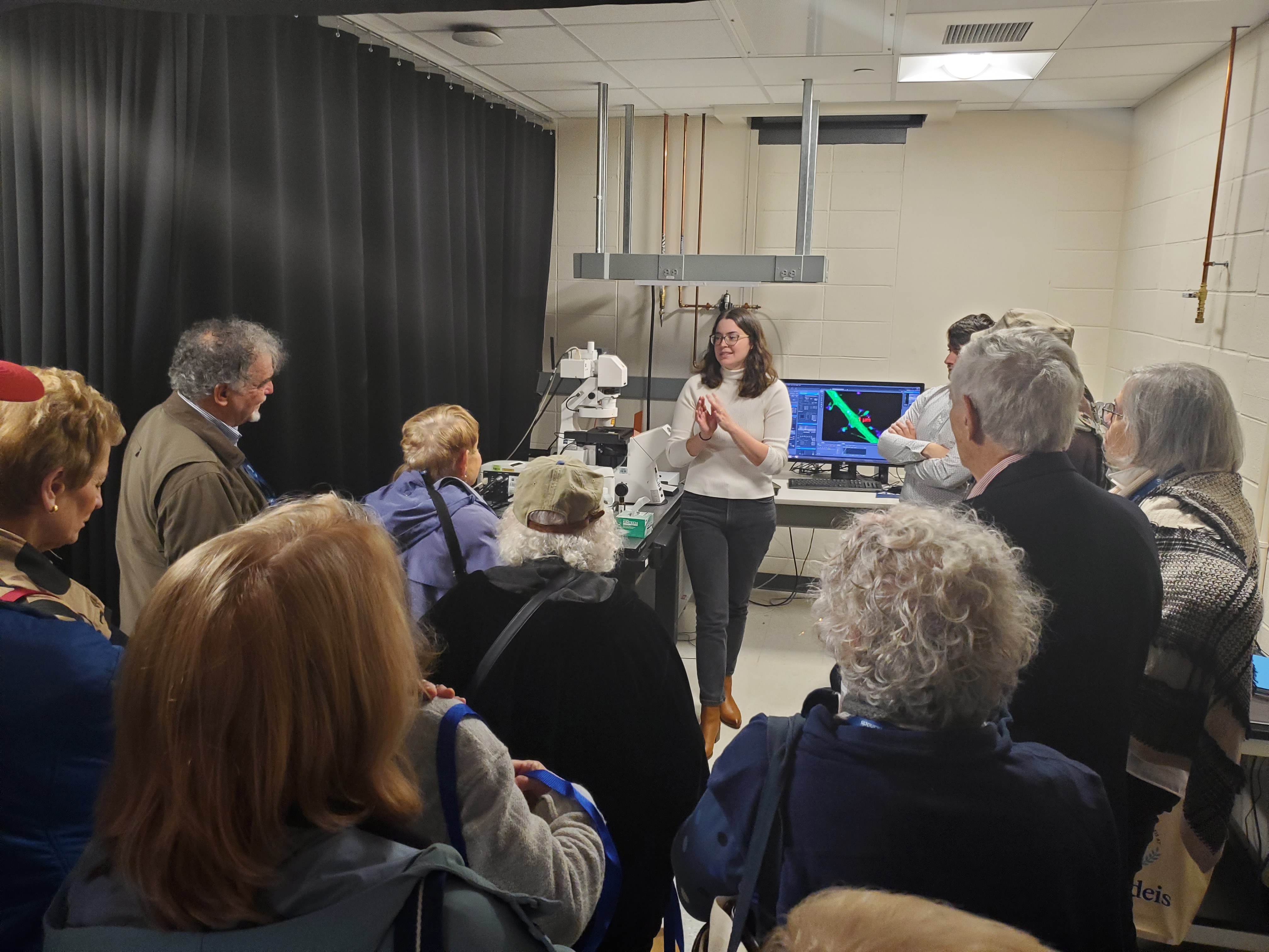 Student gives a lab presentation to BNC members on tour