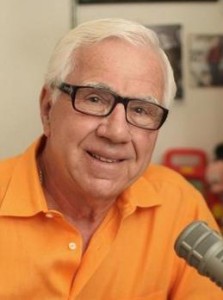 Headshot of Ron Della Chiesa wearing a bright orange shirt.