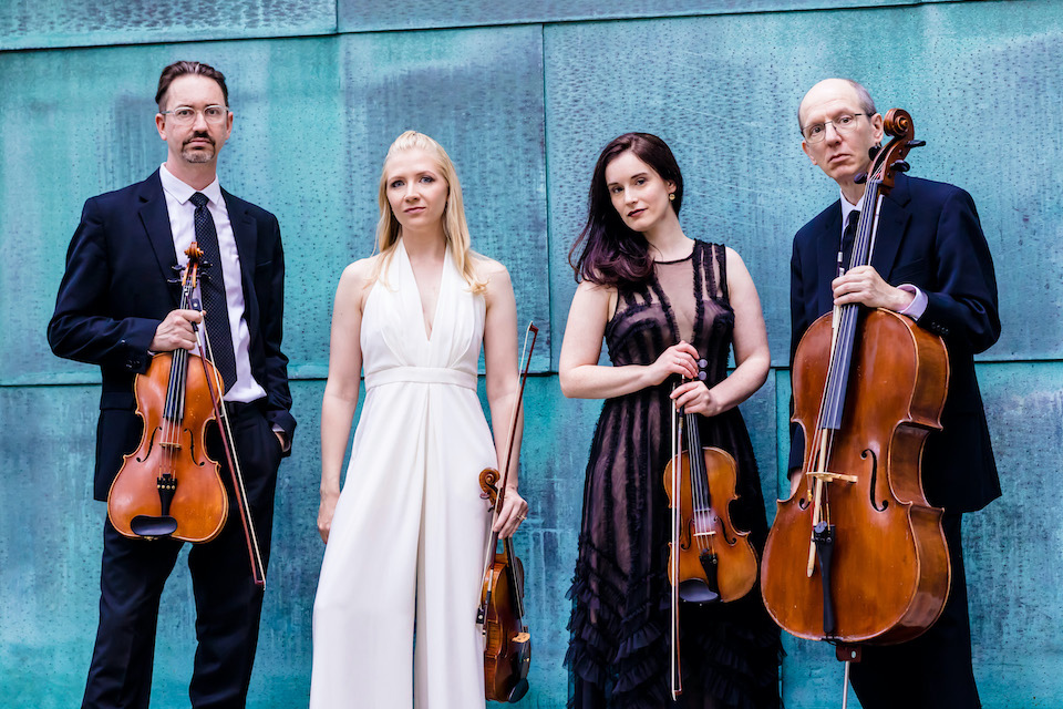 Members of the Lydian String Quartet stand with their instruments.