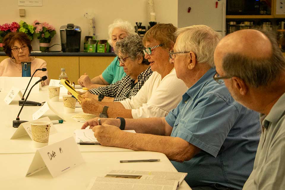 People sit at a table, panel-style