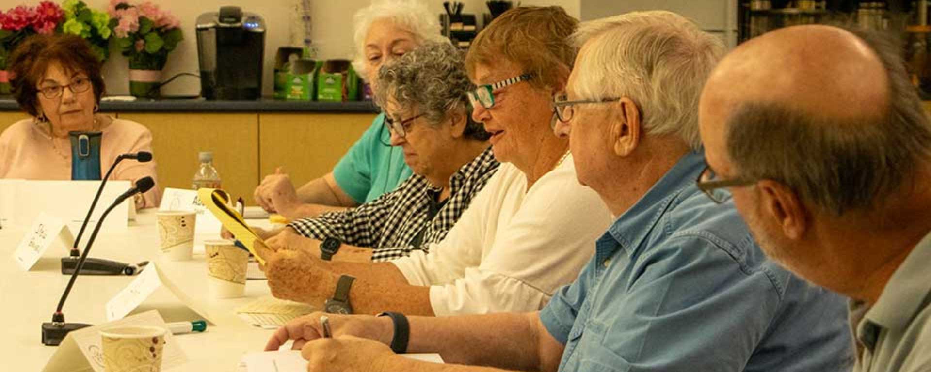 People sit at a table, panel-style