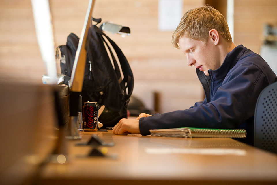 Student sits at a desk reading