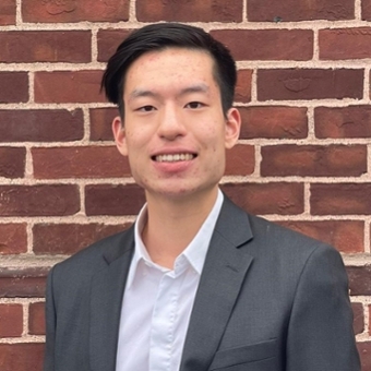 Brian Hsieh in professional attire in front of a brick wall
