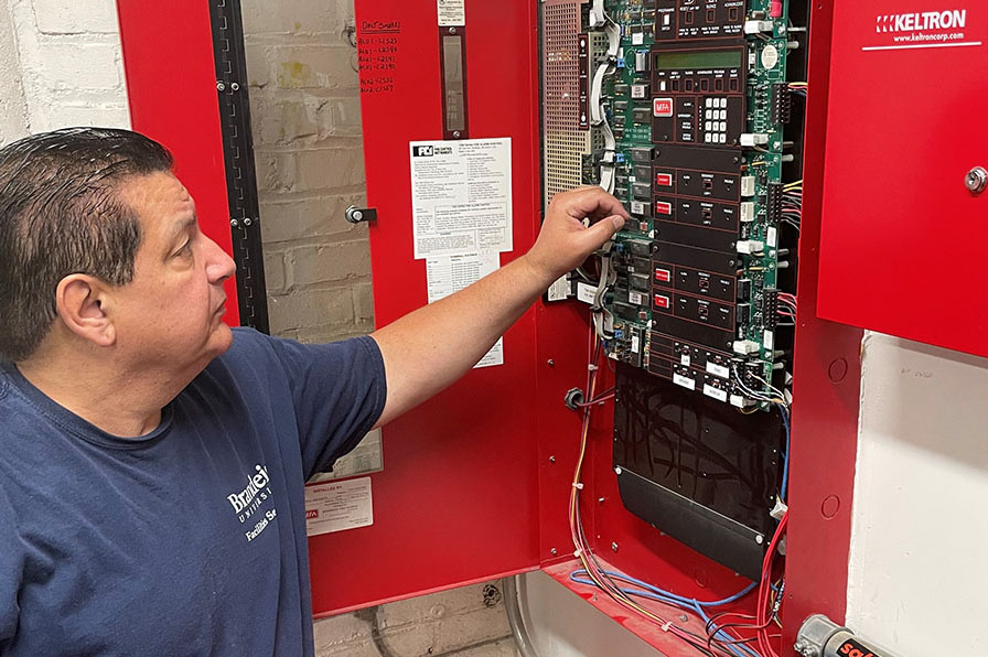 A staff member works on a fuse box